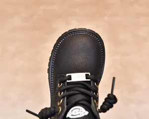 Détails de bottines pour enfants en cuir grainé noir avec œillets dorés et décor