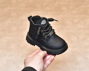 Vue détaillée des bottes en cuir noir pour enfants avec œillets dorés et semelle épaisse