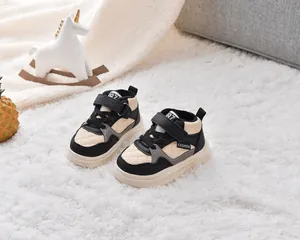 Détail de baskets hautes pour enfants avec panneaux beiges et noirs et bande velcro