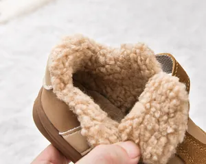Close-up of warm faux lamb wool lining and suede surface of kids winter boots
