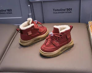 Detailed close-up of kids winter snow boots showing red waterproof fabric and thick warm lining