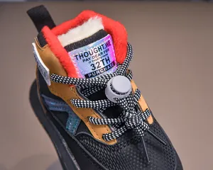 Detail of warm red faux fur lining and purple reflective tongue tag on children boots