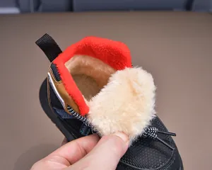 Close-up of winter boot interior featuring thick off-white faux fur lining and red trim
