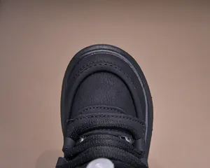 Detailed macro shot of reinforced toe and dual stitching on black winter baby shoes