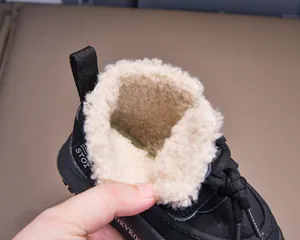 Close-up of children's winter boots featuring thick warm faux fur lining and black exterior