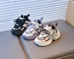 Three pairs of girls' chunky sneakers in mesh and leather on a grey soft bench