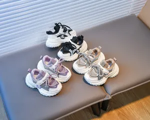 Trois paires de baskets pour enfants respirantes en noir, violet et kaki sur un banc