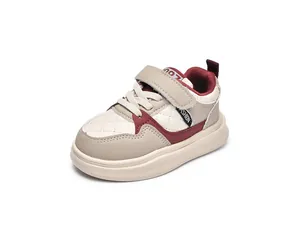 Detail view of children sports shoes featuring diamond quilting and red velcro strap