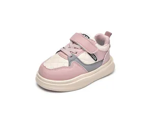 Detail of pink and white kids' sneakers featuring quilted toe and Velcro strap closure