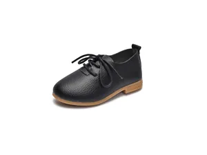 Detail of children's black leather shoes with pebble grain texture and gum sole