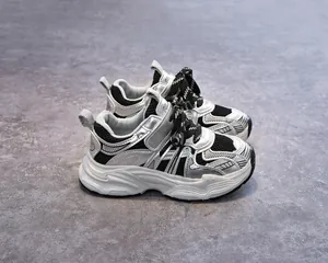 Détail de baskets pour enfants argentées avec mesh noir et lacets à rayures texturées