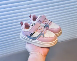 Detailed close-up of pink and white kids' sneakers with quilted patterns and velcro straps