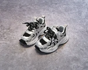 Détail macro de la maille respirante et du cuir argenté sur baskets pour enfants