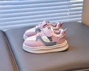 Detail of pink and white kids' sneakers showing diamond quilted side and Velcro strap