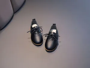 Overhead view of kids black oxford shoes with pebbled leather texture and round laces