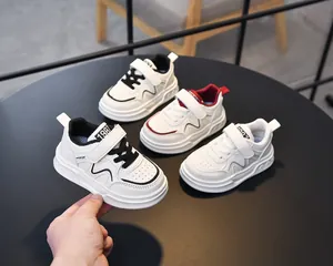 Detailed view of children's leather sneakers with velcro closure and embossed sole pattern