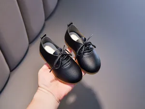 Detail of children's black leather shoes with pebble grain texture and gum rubber sole