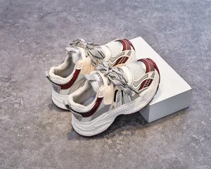 Détail de la maille respirante et des lacets rayés sur des chaussures de course pour enfants