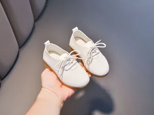 Detail of white leather kids shoes with textured surface and durable rubber sole