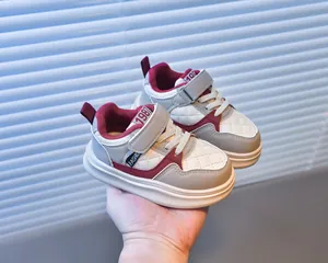 Macro detail of kids casual sports shoes with grey, red, and white quilted stitching pattern