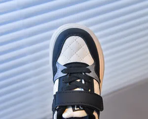 Detail view of kids' sneakers featuring diamond-quilted navy leather and rubber toe cap