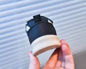 Detailed close-up of children's sneaker heel with black pull tab and thick white sole