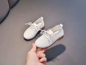 Detailed close-up of white leather Oxford shoes for kids featuring soft lychee texture
