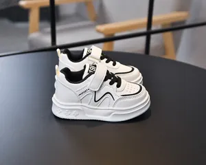 Detail of kids leather sneakers showing black accents and embossed pattern on sole