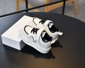 Detail view of white leather kids sneakers with Velcro strap and breathable toe design