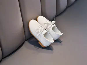 Detail of white leather kids shoes with textured finish and durable gum rubber sole