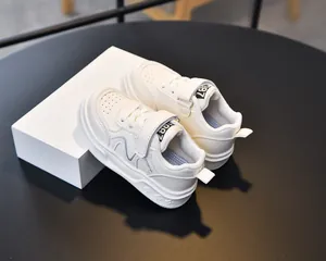 Close-up of kids white leather sneakers with velcro strap and breathable toe box