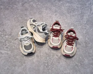 Close-up of children's mesh athletic shoes in grey and burgundy showing breathable textures