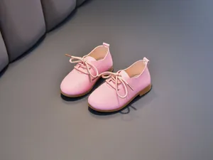 Close-up of pink children's leather shoes with litchi texture and anti-slip sole