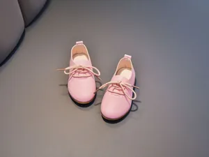 Close-up of pink round-toe children leather shoes with cotton laces and gum soles