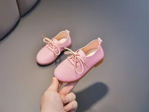 Close-up of pink toddler girls leather shoe with lychee grain and lace-up details