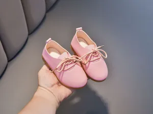 Detailed close-up of pink matte toddler shoes with lace-up bow and soft texture