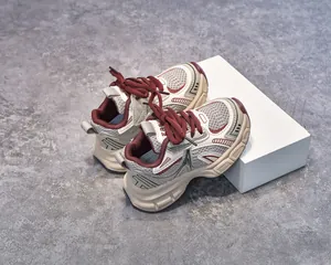 Detail of kids' athletic sneakers featuring grey mesh and cream synthetic leather