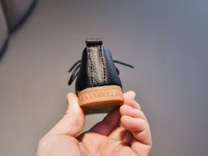 Close-up of children's black leather shoes featuring non-slip brown rubber gum soles