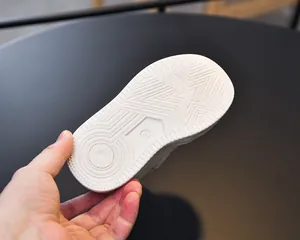 Detailed view of white rubber sneaker sole featuring anti-slip star and circular patterns