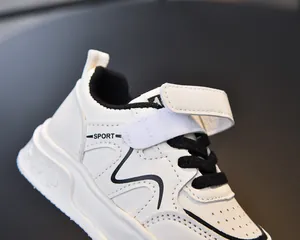 Detail of white kids sneakers with velcro straps and sport text on high-quality leather