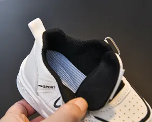 Close-up of children's white faux leather sneakers showing sporty mesh lining and detail