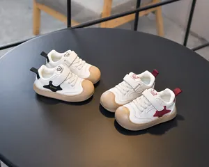 Detail view of anti-slip rubber toe caps on white children sneakers with star patterns