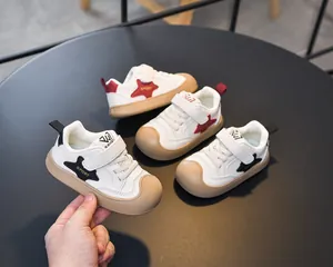 Detail of white kids sneakers with velcro straps and protective non-slip rubber toe caps