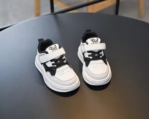 Détail de chaussures de sport pour enfants en cuir noir et blanc avec scratch
