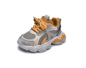 Detail of toddler sneakers featuring breathable mesh, vibrant orange laces and chunky sole