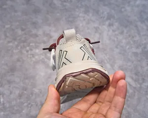 Detail of the heel and pull tab on breathable beige and maroon kids sports sneaker