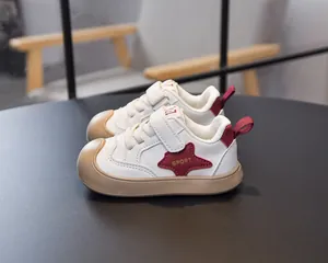Detail of toddler sneakers featuring a rubber toe cap and side red star patch
