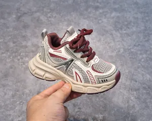 Close-up of children's retro sneakers featuring beige mesh and burgundy lace detail