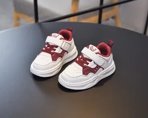 Vue de dessus de baskets enfants en cuir blanc avec détails bordeaux et fermeture velcro