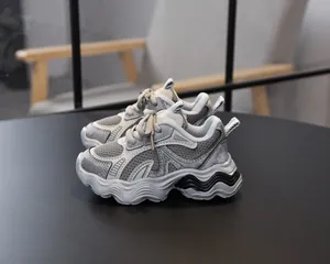 Detailed close-up of girls' breathable silver mesh sneakers with thick wavy soles